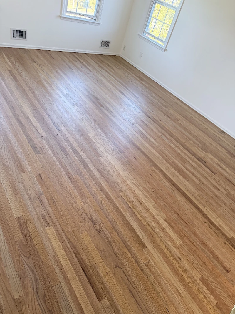 Red oak strip floor in an empty room, natural finish, light coming from two windows