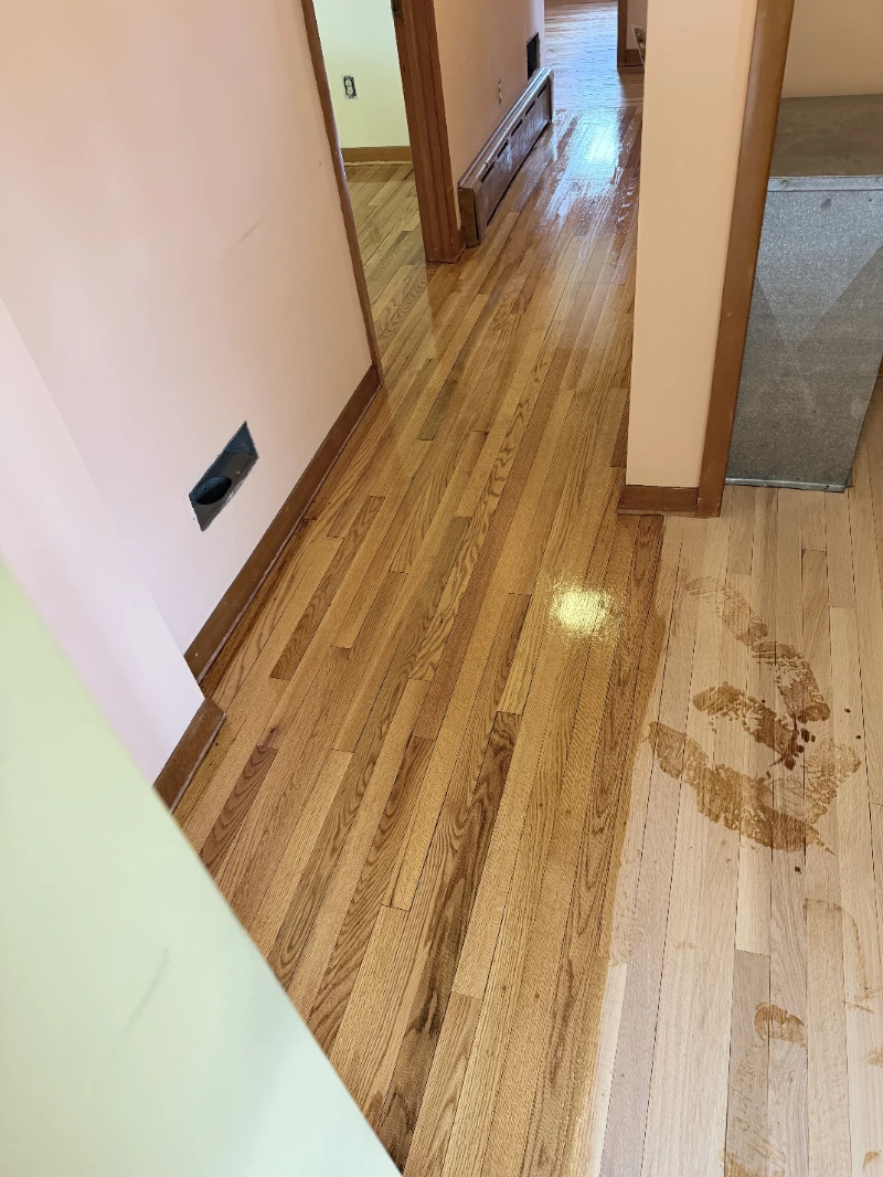 Hallway mid-job: the finished half of the oak floor beside the section still to be done
